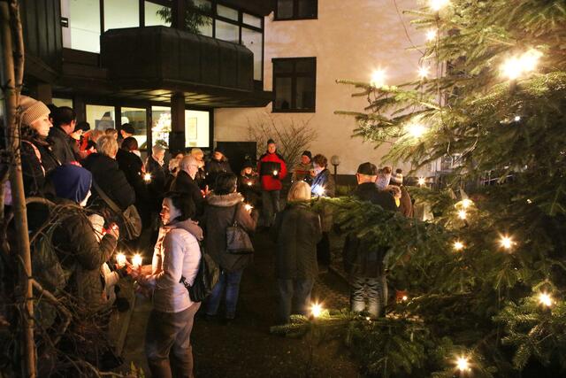 Vor dem Rathaus trafen sich viele Menschen am Sonntagabend, um ein Friedenslicht anzuzünden und mit Pfarrerin Grasruck zu beten. | Foto: Andreas Unbehaun
