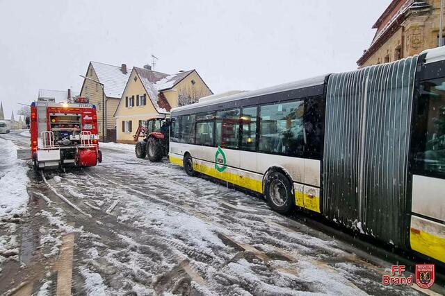 In Brand blieben aufgrund der starken Schneefälle am Donnerstagmorgen zwei Linienbusse hängen und konnten erst weiterfahren, nachdem sie mit Hilfe von schweren landwirtschaftlichen Fahrzeugen wieder freigeschleppt wurden. | Foto: Feuerwehr Brand