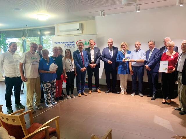 Eingebettet in die Helfer der Nachbarschaftshilfe: Dr. Ewald Maier (8. v. li.), daneben Dr. Tobias Mähner, Innenminister Joachim Herrmann, 1. Bürgermeisterin Ilse Dölle, Karl-Heinz Link, Landrat Alexander Tritthart und Franz Kränzler (v.li.) | Foto: Privat