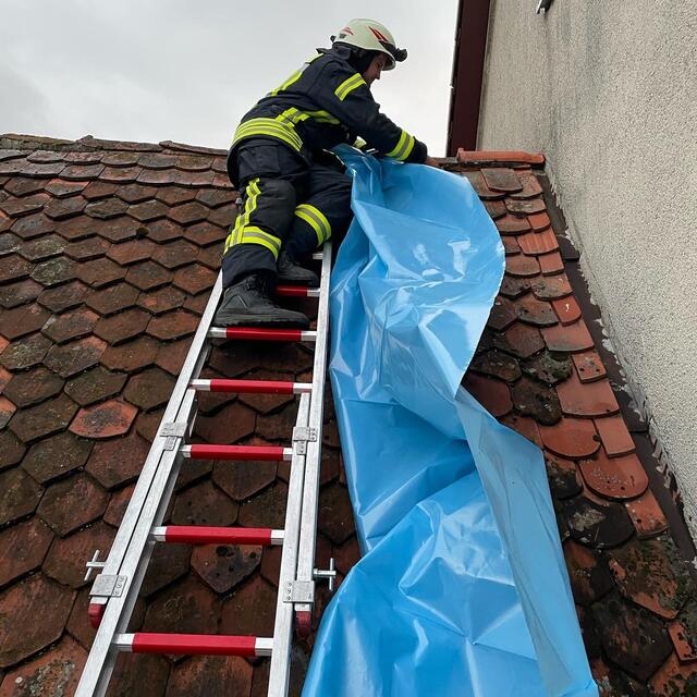 Ein Dach musste notdürftig abgedichtet werden, nachdem ein Blitz in ein Haus im Kalchreuther Ortskern eingeschlagen war. | Foto: Feuerwehr Kalchreuth