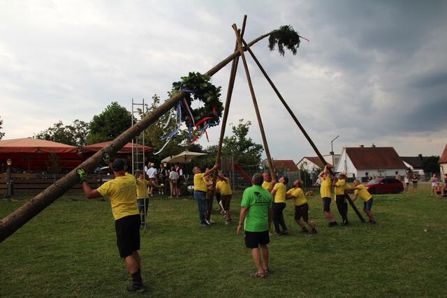 Jetzt muss der Baum ins Lot, unter der Anleitung von „Capo” Roly Igel (in Grün) packt auch Festwirt Hermann Reif an der 1. Schwalbe (Bildmitte) kräftig mit an. | Foto: Georg Heck