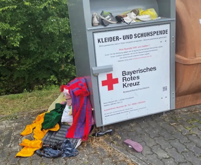 Der Altkleidercontainer beim Feuerwehrhaus in Pettensiedel ist voll. Jetzt liegt gespendete Kleidung schon seit längerem neben dem Container. | Foto: Privat