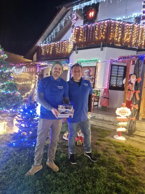 Peter Seitz (1. Vorstand, auf dem Bild rechts) und Christian Gebhardt (2. Vorstand) vom Verein "Dorfgemeinschaft Letten" vor dem Lettener "Weihnachtshaus" mit der Spendenbox für "Wünschewagen Franken/Oberpfalz", oben auf dem Balkon kann man das "Adventsfenster" mit der Zahl "11" sehen. | Foto: Dorfgemeinschaft Letten