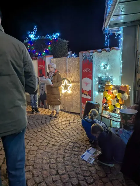 Bevor sich die Gartentür zum "Weihnachtshaus" öffnete, begrüßte Gabi Oost die Gäste (in Vertretung von Manfred Finkes, der diese Aufgabe in den vergangenen Jahren immer übernommen hatte)und beschrieb kurz die Aufgaben des "Wünschewagens", dem diesjährigen Spendenzweck, und trug passend dazu ein Gedicht über einen letzten Wunsch vor. | Foto: Dorfgemeinschaft Letten