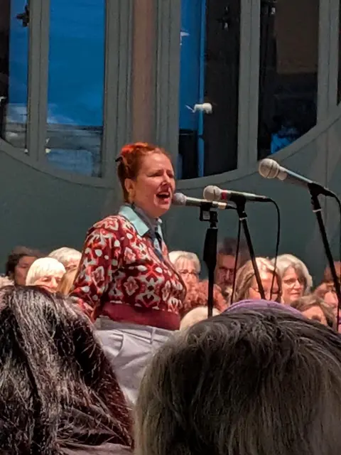 Astrid Lierenfeld, Chorleiterin, in Interaktion mit dem Publikum  | Foto: Pfarrer Dr. Stefan Opferkuch