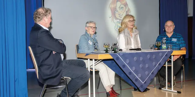 Podiumsgespräch mit Uwe van Olfen (Leiter des Fotoclubs) Veronika Deckart (die viel Interessantes zu FLEck zu erzählen wusste), Bürgermeisterin Ilse Dölle, als besonderes Gesprächsmitglied „FoKi” (die Fotoclub-KI, die sich immer wieder in das Gespräch einklinkte) und Klaus Fleischmann als dienstältestes Mitglied des Fotoclubs (von links nach rechts). | Foto: Eduard Baumann