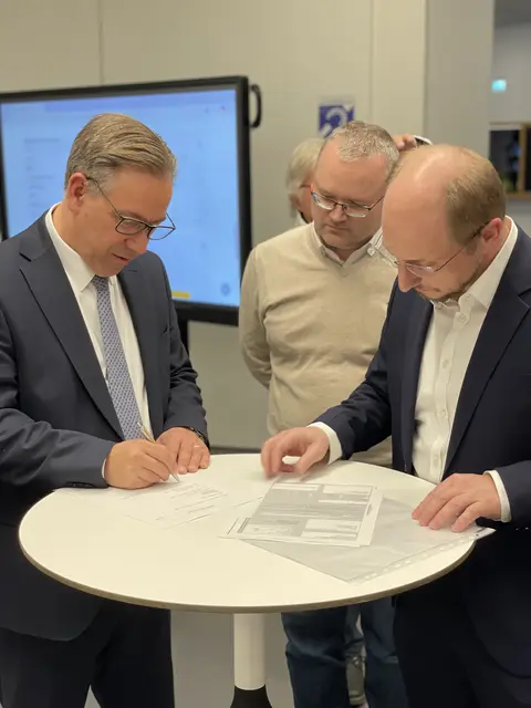 Landrat Alexander Tritthart (links) bei der Unterzeichnung der Annahmeerklärung in der Wahlnacht. Wahlleiter Manuel Hartel (rechts) und Michael Stötzel, Sachgebietsleiter der Kommunalaufsicht, gratulierten. | Foto: Landratsamt ERH/Stephanie Mack