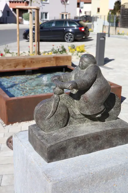 Die Bronze-Skulptur der kalchreuther Bildhauerin Monika Ritter zeigt eine stilisierte Radfahrerin, wie sie vor vielen Jahren mit Kopftuch und wehenden Kleidern durch den Ort gefahren sein könnte. | Foto: Andreas Unbehaun