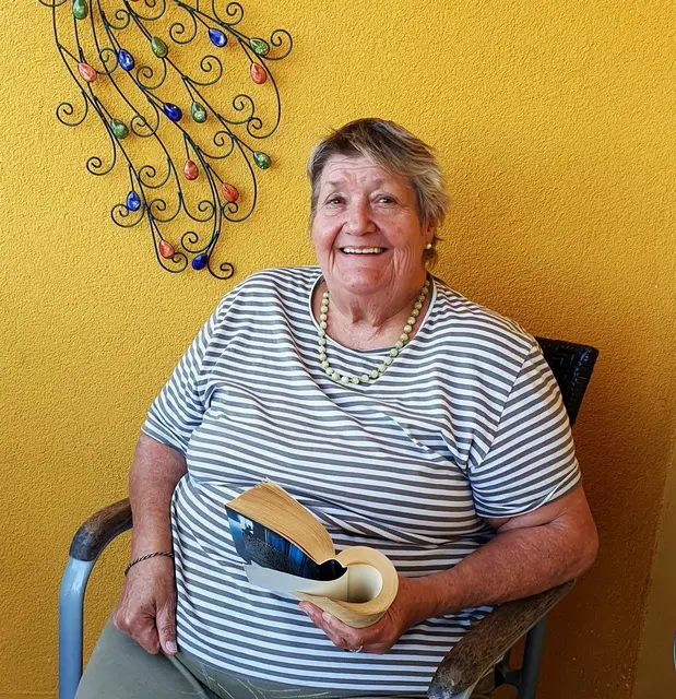 Fröhliche Bewohnerin beim Lesen eines der Bücher aus dem offenen Bücherregal im öffentlichen Cafe des Seniorenheim Martha-Maria  | Foto: Annegret Schildknecht 