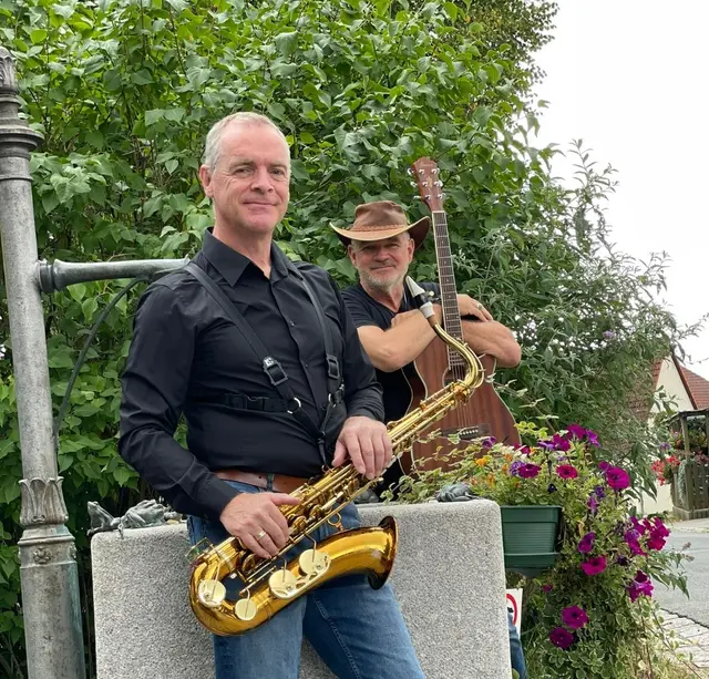 Alfred Zens (vorn) und Eric Damster am Lettener Dorfbrunnen. Die beiden werden zusammen mit Verena  Riehr für sommerliche Party-Stimmung sorgen. | Foto: Eric Damster