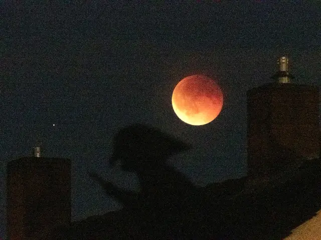 Am Sonntagabend war am Himmel ein nicht alltägliches Phänomen zu sehen. Bei totaler Mondfinsternis war der im Schatten der Erde über den Abendhimmel ziehende Vollmond als rötlich leuchtende Scheibe zu sehen. Wolfgang Stahl „erwischte” den Erdtrabanten zusammen mit einer Hexe. Die war aber nicht echt, sondern „nur” eine Wetterfahne auf einem Hausdach. | Foto: Wolfgang Stahl
